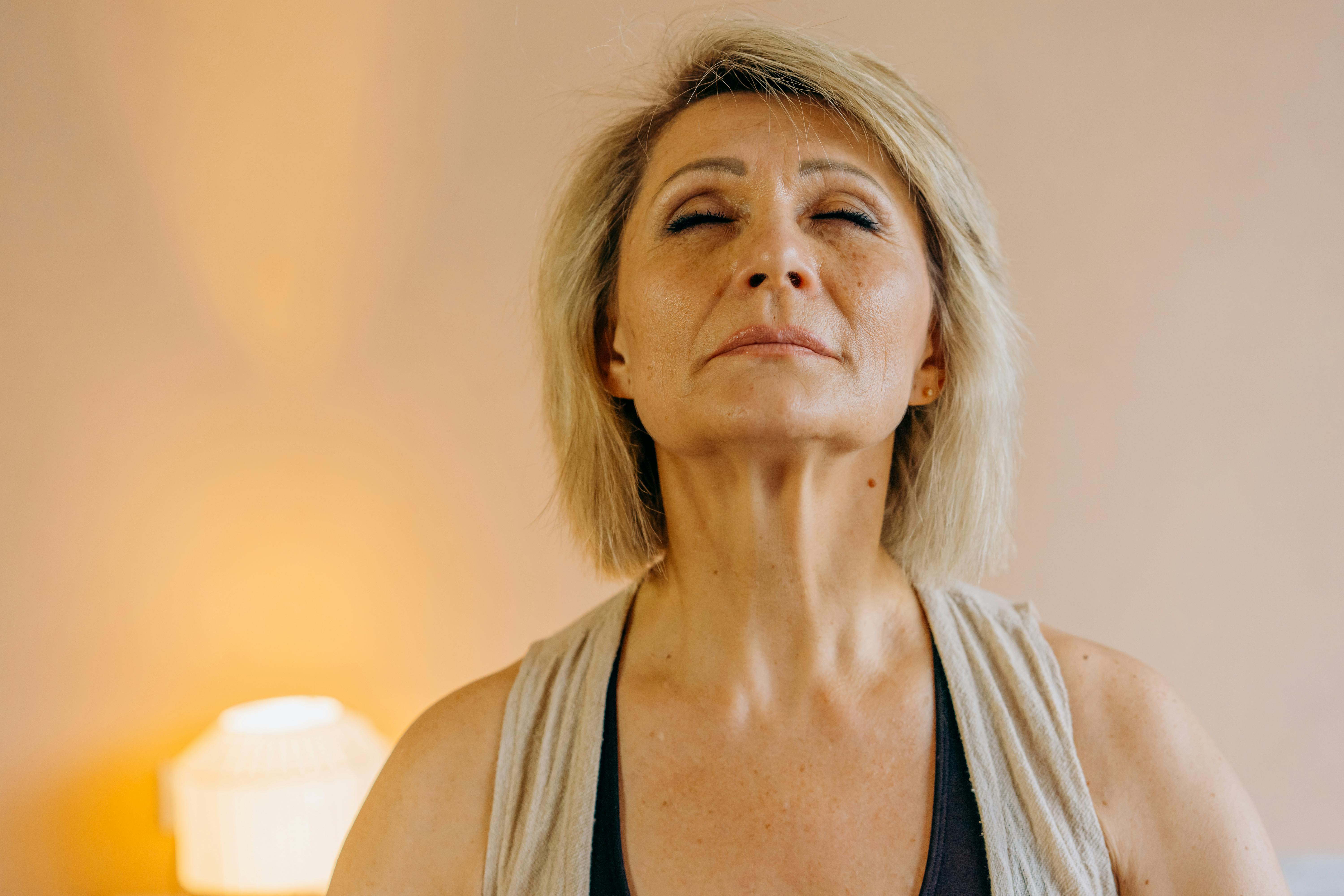 Woman over 45 looking at skin in mirror experiencing hormonal changes